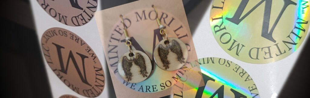 Handmade angel wing earrings with Minted Mori packaging and holographic logo stickers.
